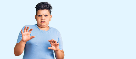 Little boy kid wearing sports workout clothes disgusted expression, displeased and fearful doing...