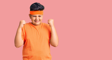 Little boy kid wearing sportswear excited for success with arms raised and eyes closed celebrating victory smiling. winner concept.