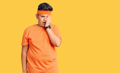 Little boy kid wearing sportswear yawning tired covering half face, eye and mouth with hand. face hurts in pain.