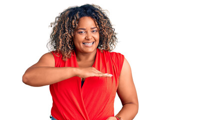 Young african american plus size woman wearing casual style with sleeveless shirt gesturing with hands showing big and large size sign, measure symbol. smiling looking at the camera. measuring concept