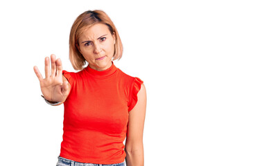 Obraz na płótnie Canvas Young blonde woman wearing casual clothes doing stop sing with palm of the hand. warning expression with negative and serious gesture on the face.