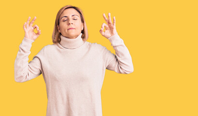 Young blonde woman wearing casual clothes relax and smiling with eyes closed doing meditation gesture with fingers. yoga concept.