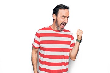 Middle age handsome man wearing striped t-shirt standing over isolated white background pointing thumb up to the side smiling happy with open mouth