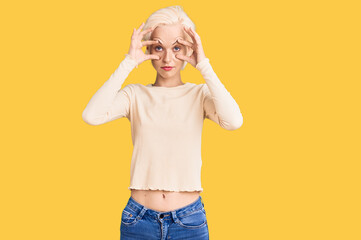 Young blonde woman wearing casual clothes trying to open eyes with fingers, sleepy and tired for morning fatigue