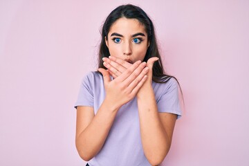 Brunette teenager girl wearing casual clothes shocked covering mouth with hands for mistake. secret concept.