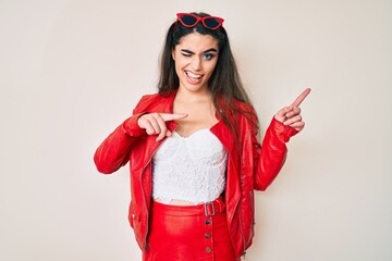 Brunette teenager girl wearing red leather jacket winking looking at the camera with sexy...