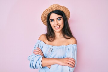 Brunette teenager girl wearing summer hat happy face smiling with crossed arms looking at the camera. positive person.