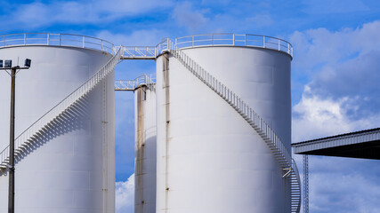 White storage fuel tanks against cloudy in blue sky background