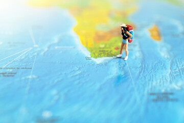 Minature people: traveling with a backpack standing on world map, Travel and summer concept.