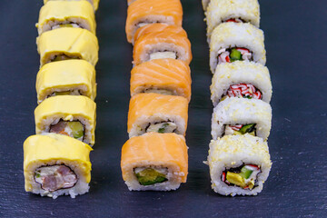Set of sushi rolls on a black stone slate