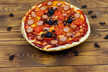 Halloween pizza with spiders on wooden table