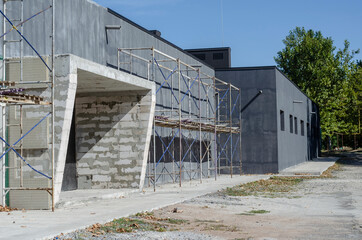 Scaffolding near a gray one-story building.