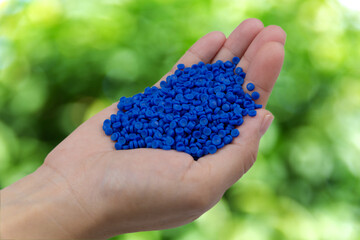Close-up of plastic polymer granules. hand hold Polymer pellet on nature background. polymer...