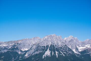 Fototapeta na wymiar Bergkette vor einem blauen Himmel. Segelflugzeuge kreisen weit entfernt