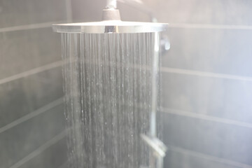 Hot water is poured from rain shower in bathroom. Bathroom plumbing concept.