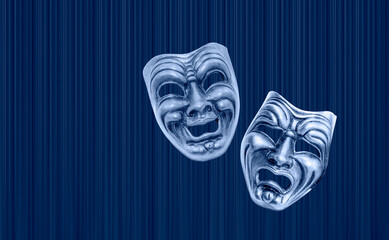 Comedy and Tragedy theatrical venetian mask with blue theater curtain