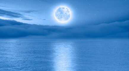 Naklejka na ściany i meble Full moon rising over empty ocean at night 