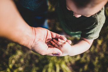 Mano de papá agarrando la mano de bebé