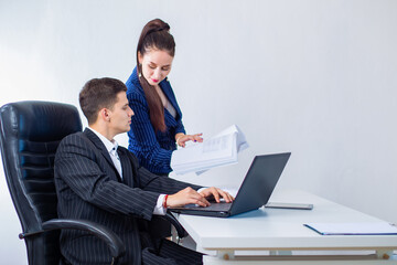 Office workers. Man and woman work in office. Woman shows man documentation. Leader and secretary. Secretary shows documents to manager. Young businessman and his secretary. Businessman
