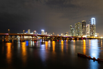 Fototapeta na wymiar Miami Florida, sunset panorama with colorful illuminated business and residential buildings and bridge on Biscayne Bay. Miami downtown.