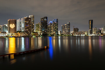 Fototapeta na wymiar Miami sunset panorama with colorful illuminated business and residential buildings and bridge on Biscayne Bay. Miami skyline on Biscayne Bay, city night backgrounds.