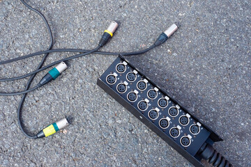 Technical concept. Wires with plugs and power supply on the background of the pavement. Connecting devices to the power supply. Equipment operation on the street.