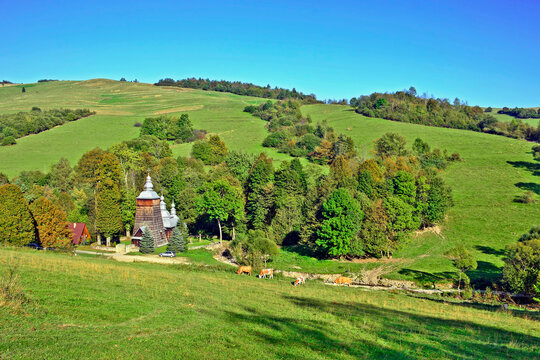 Rural landscape in Low Beskids (Beskid Niski) with wooden orthodox church in Chyrowa village, Poland