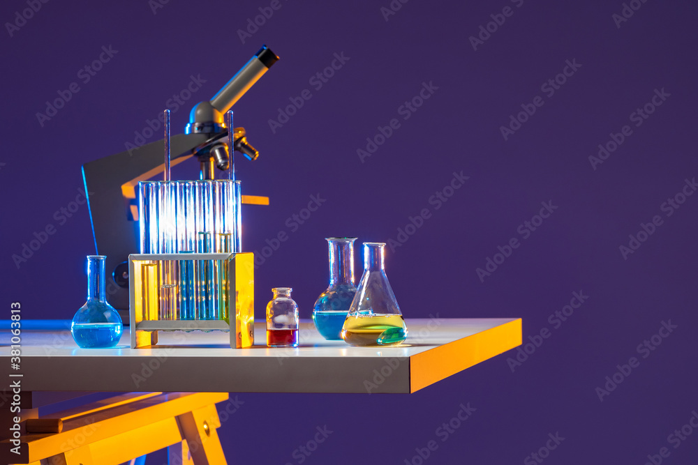 Poster table with a microscope and test tubes. flasks with multicolored chemical liquids and a microscope o