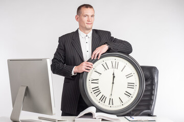 Time management. A man in a business suit leans on a large clock. Timely completion of tasks....