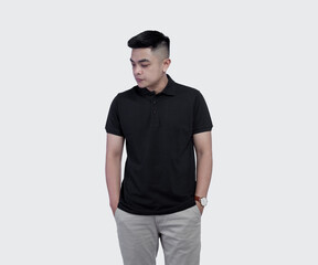 Fototapeta premium Close Up shot of handsome man wearing black polo shirt posing at plain background