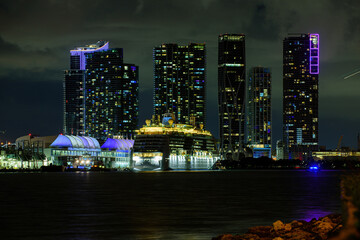 Cruise ship in the Port of Miami at sunset with multiple luxury yachts. Miami night downtown, city Florida. Night view of cruise liners near Miami Port.