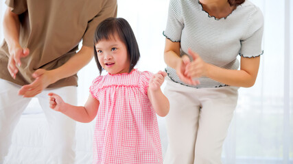 Happy family with mother, father and disabled daughter spending time together at home.