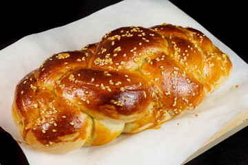challah Jewish bread on white paper and  black background.  