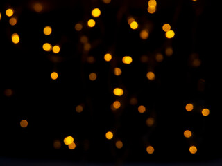 A small bokeh background shining golden light at night, which looks like a fire.