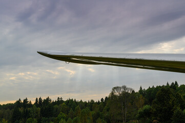 the sun's rays make their way through the clouds under the wing of the glider