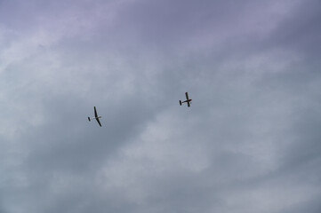 Naklejka na ściany i meble a glider towed by a plane in cloudy sky