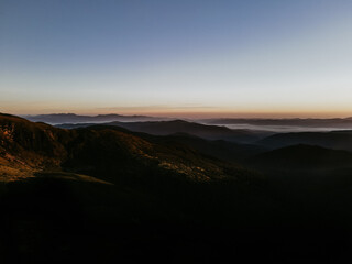 View of the Carpathian Mountains. Green forest against the sky, rocky mountains and beautiful landscape. Autumn in the mountain and forest trees. Mountain view on the sunrise with clouds