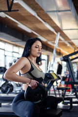 Fit woman in gym exercise with weight on sunny morning