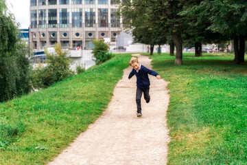 the boy runs quickly along the path, arms to the sides