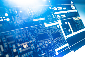 PCB board close-up. Light through the PCB. Background on the theme of computer production. The texture consists of a printed circuit board. Background from PCB board with microchips.