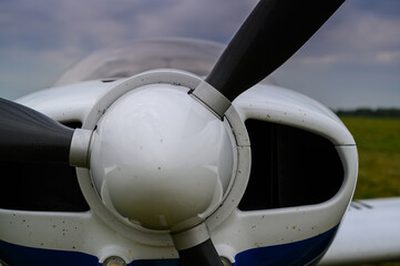 small single-engine civil airplane on a green grass of a countryside airdrome