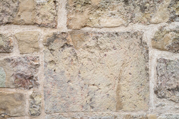 Assymetric masonry of different size natural stone blocks. Wall pattern.