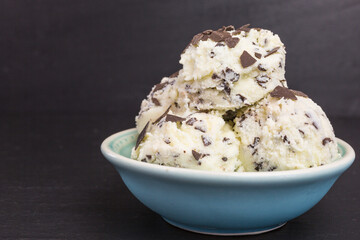 fresh stracciatella ice cream scoops with flakes of dark chocolate in a bowl