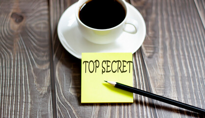 Business TOP SECRET . Yellow stickers with text on wooden background with coffee