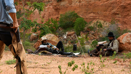 Cowboys duel with enemies that are resting in the camp..