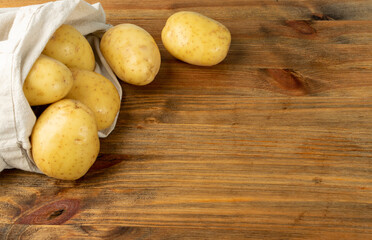 Raw Potatoes on Wooden Cutting Board Background