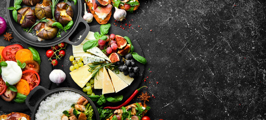 Fototapeta na wymiar Food: cheese, figs, mushrooms, meat and vegetables. European and Asian cuisine. Healthy food on a black stone background. Top view.