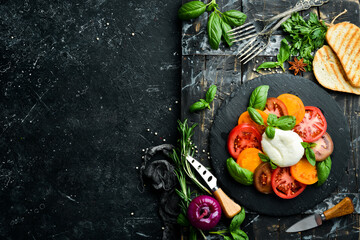 Caprese salad with fresh tomatoes, mozzarella cheese and basil. Italian food. Top view.