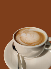 A cup of Coffee with brown background.