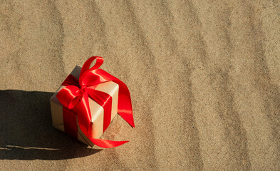 Christmas shopping. Gift on sand background